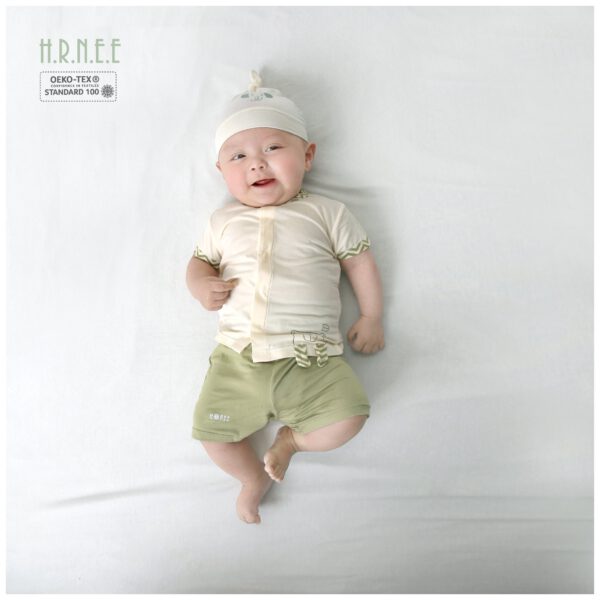 em bé mặc bộ cộc tay đội mũ nằm chơi