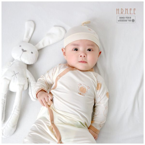 em bé nằm cạnh thỏ bông