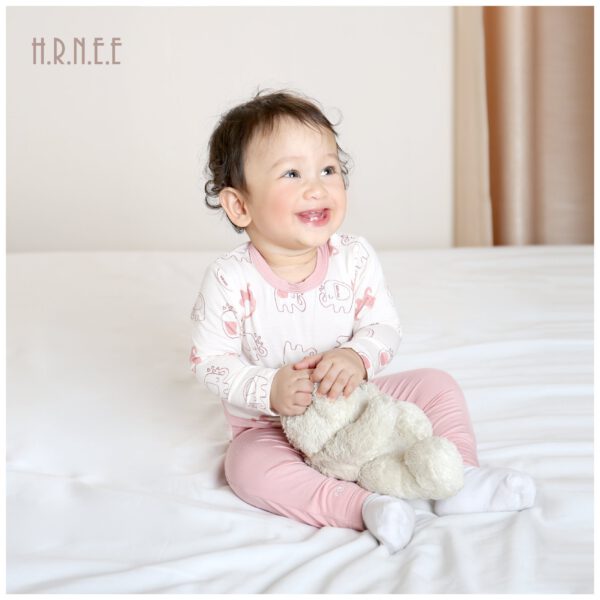 em bé ôm gấu bông cười