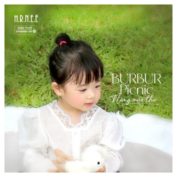 bé gái ôm gấu bông mặc áo sơ mi tay bồng phối ren điệu đà